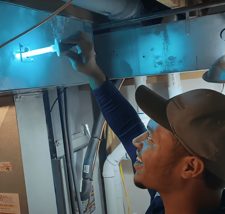 Logan Services HVAC technician installing UV air purifier.
