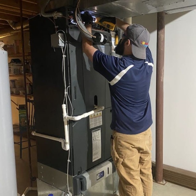 Logan Services HVAC technician performing maintenance on air handler.