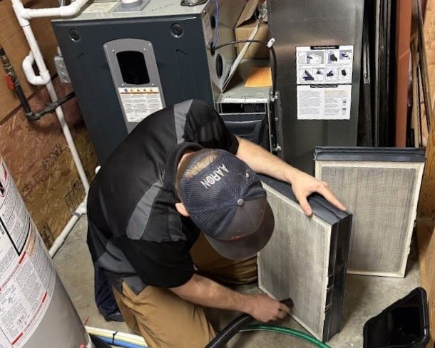 Logan Services HVAC technician cleaning a Perfect Air Plus filter.