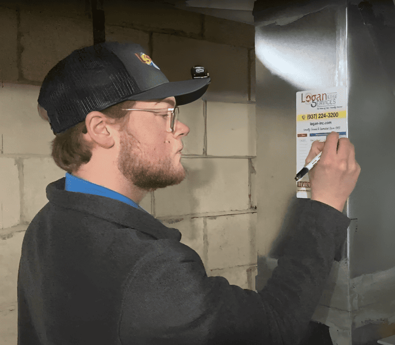 Logan Services HVAC technician finishing furnace tune-up.