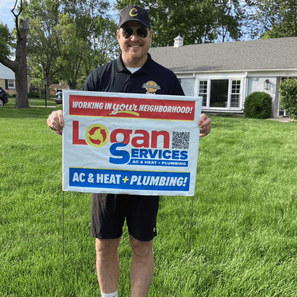 Happy customer showing off Logan Services yard sign.