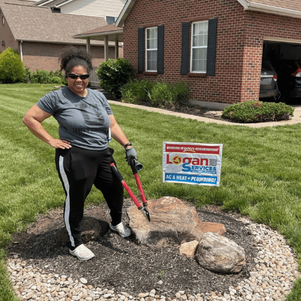 Woman paused yard work to show off her Logan Services yard sign.