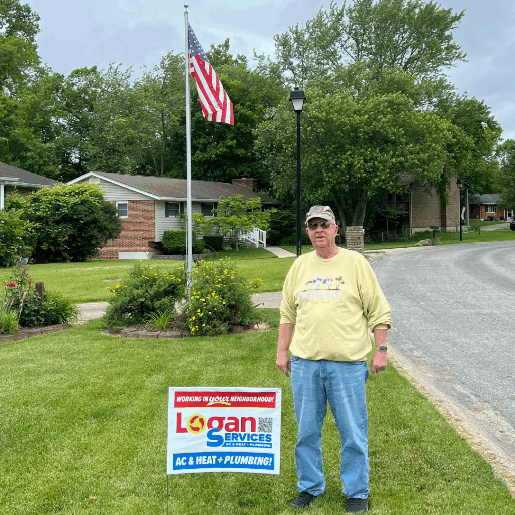Customer posing with Logan Services yard sign and American flag.
