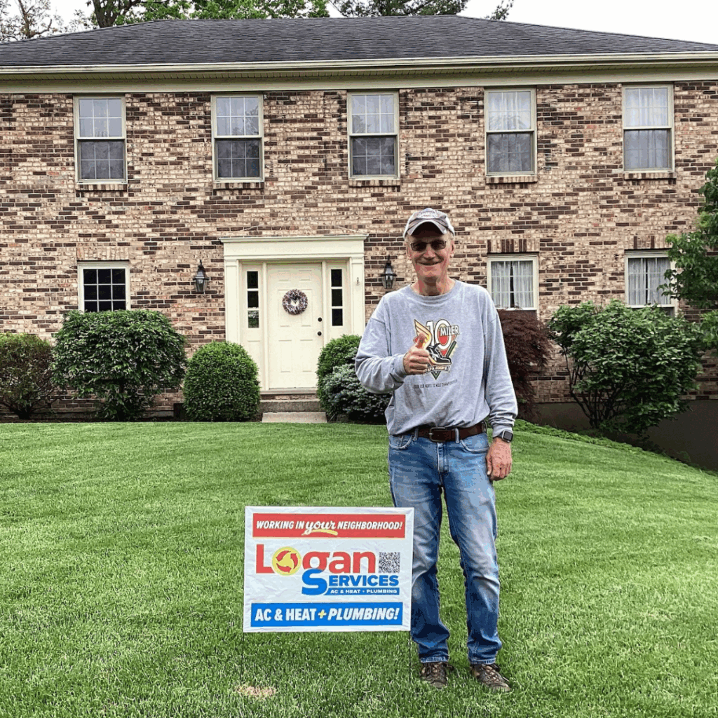 Customer in front of a large house giving a thumbs up with his Logan Services yard sign.