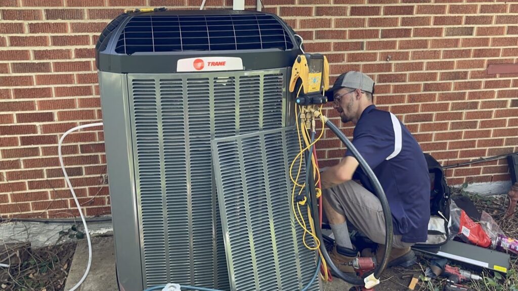 Logan Services HVAC technician installing an air conditioner.