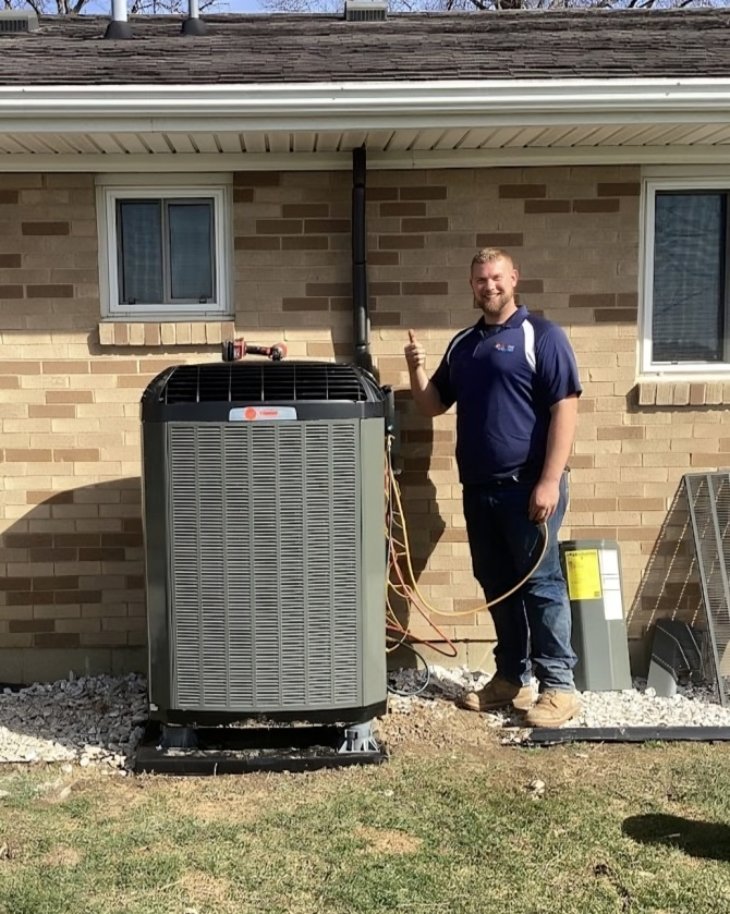 Logan Services HVAC technician posing with Trane unit