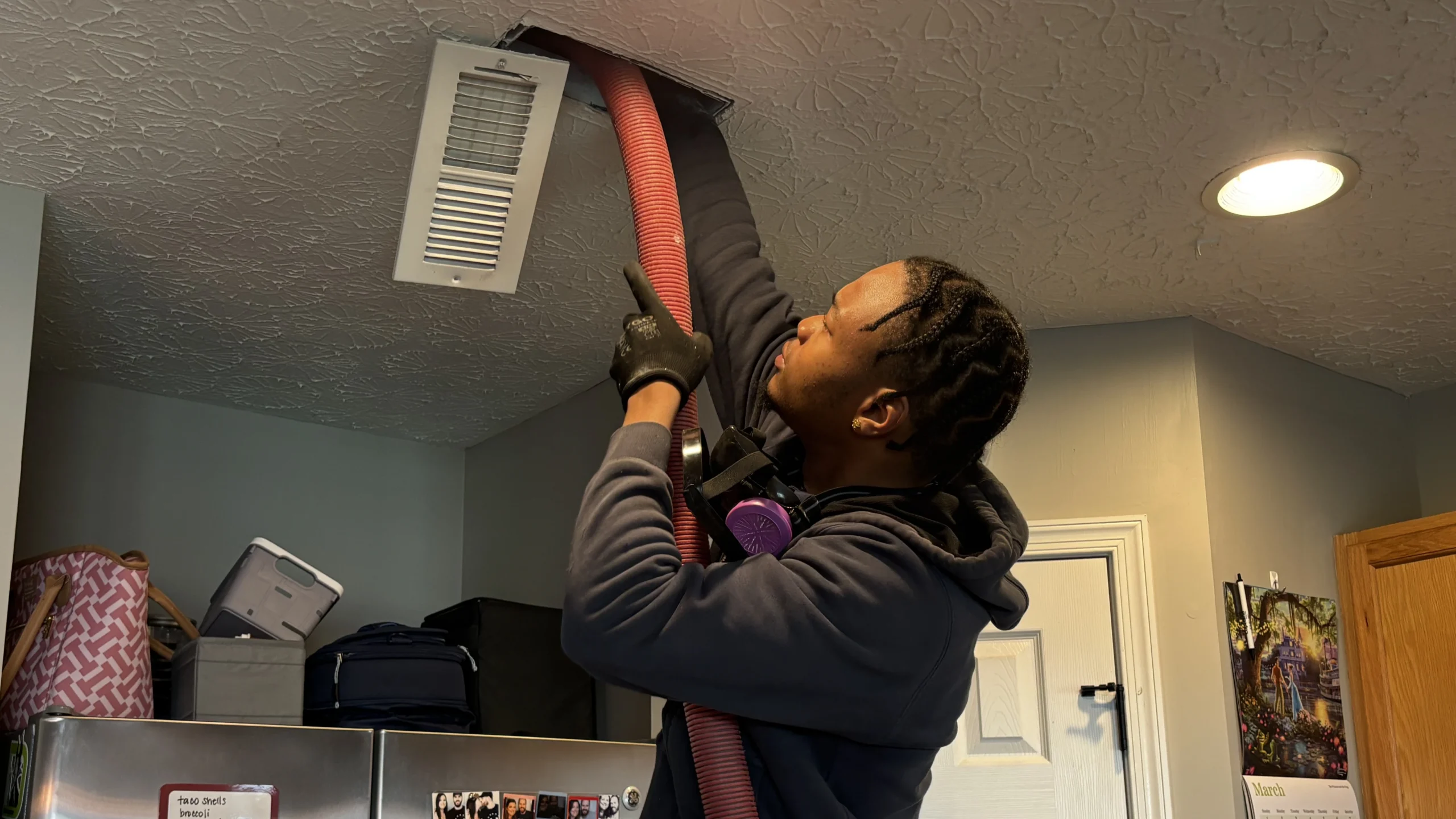 Logan Services technician cleaning ceiling vents