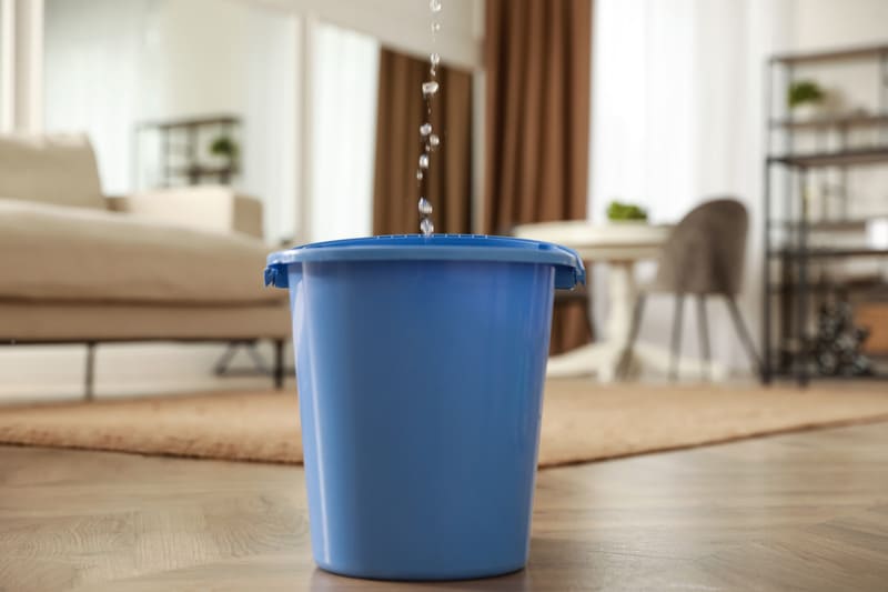 bucket collecting water from leaking ceiling