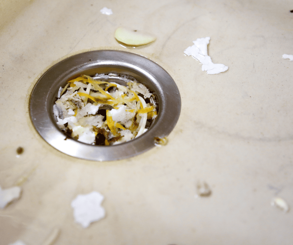 A clogged garbage disposal filled with food waste