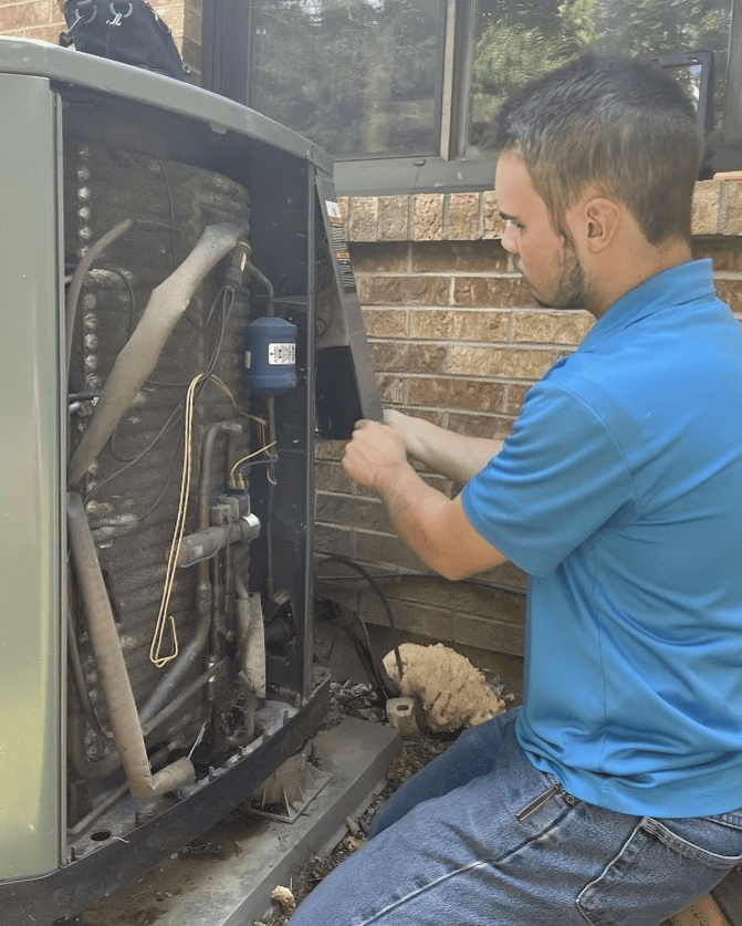 Logan Services HVAC technician repairing an air conditioner unit.
