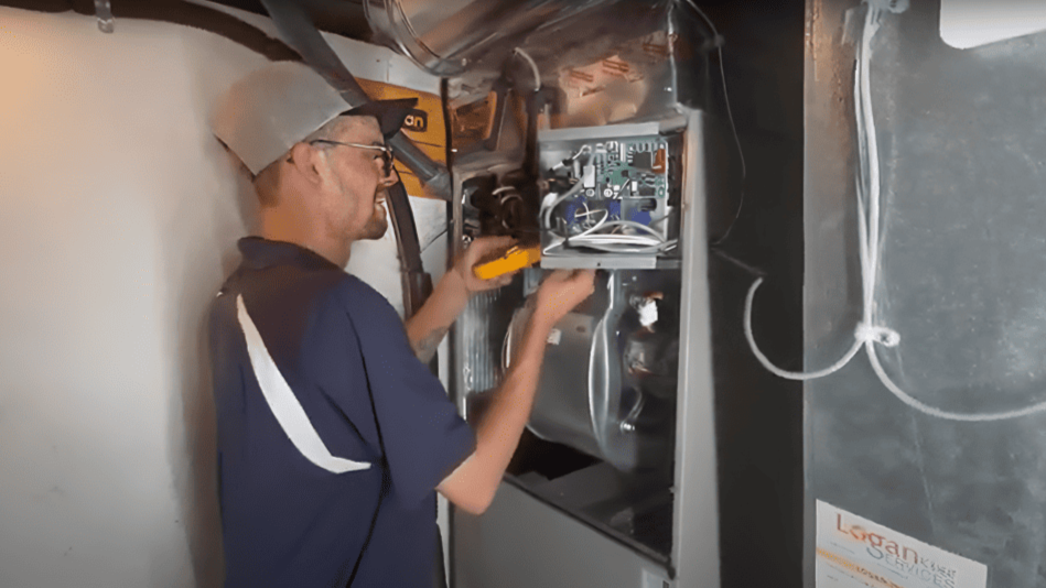 Logan Services HVAC technician performing system checks on furnace in Dayton, OH.