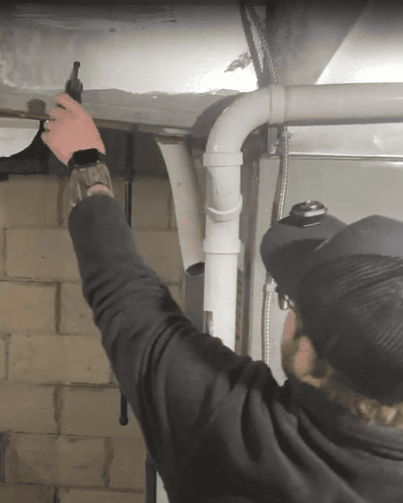 Logan Services HVAC technician inspecting furnace ductwork.