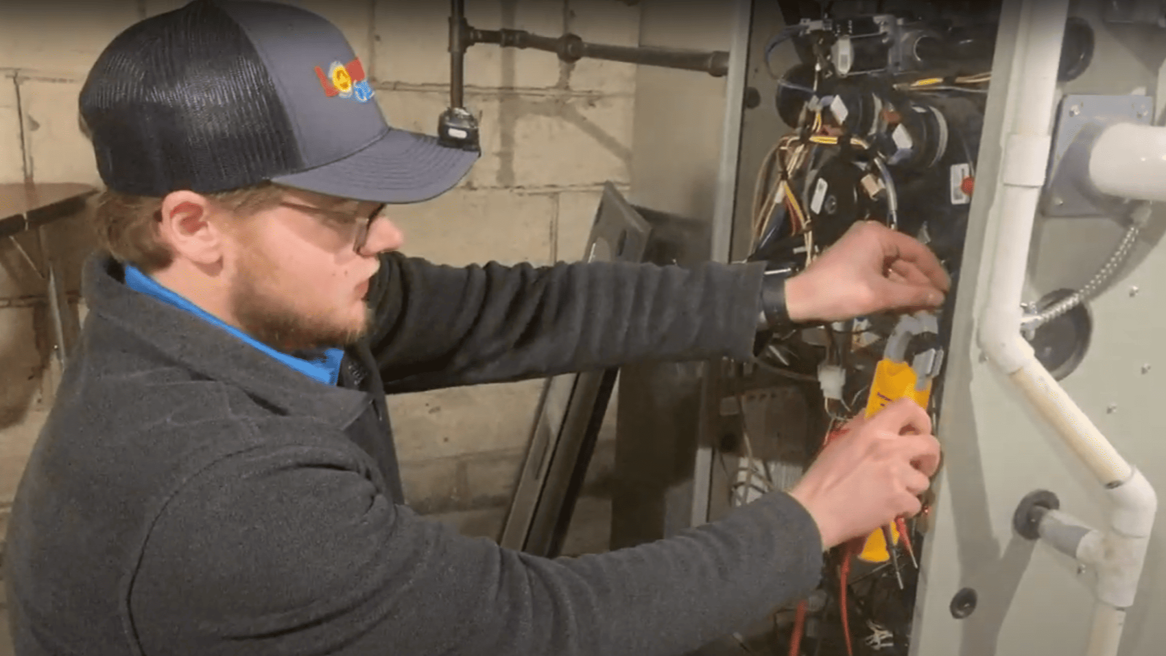 Logan Services HVAC technician performing furnace maintenance.