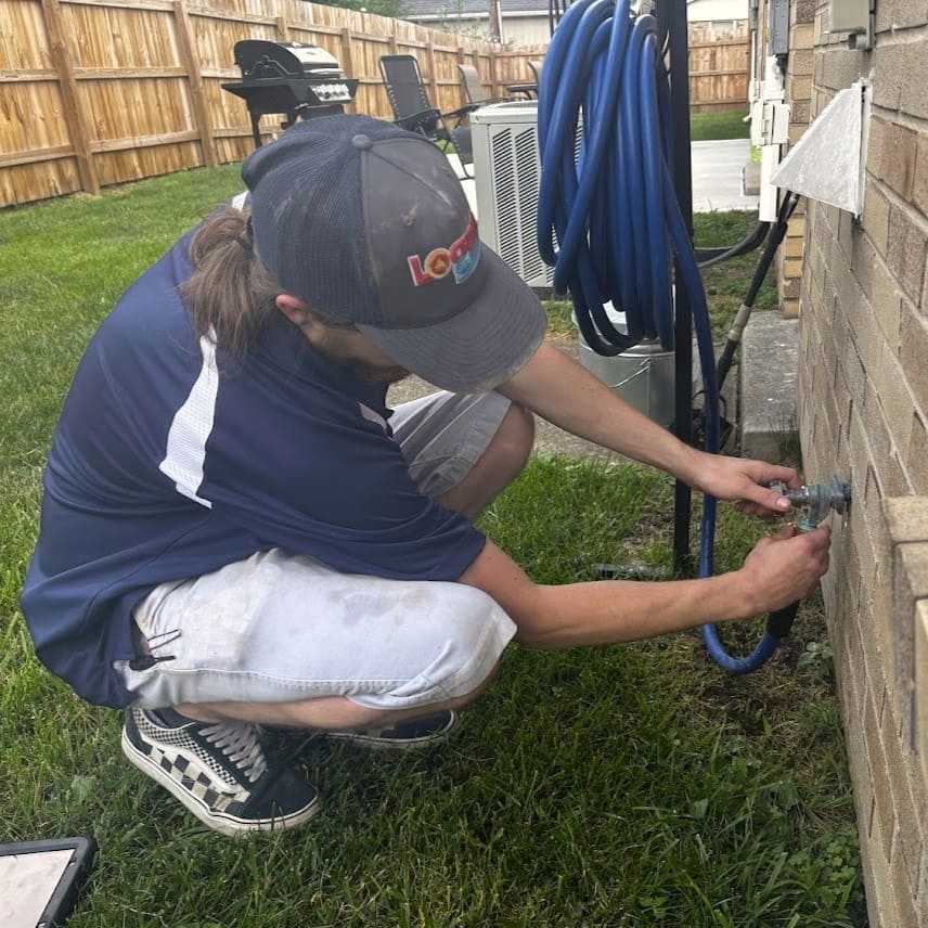 Logan Services Plumber inspecting outdoor hose bib.