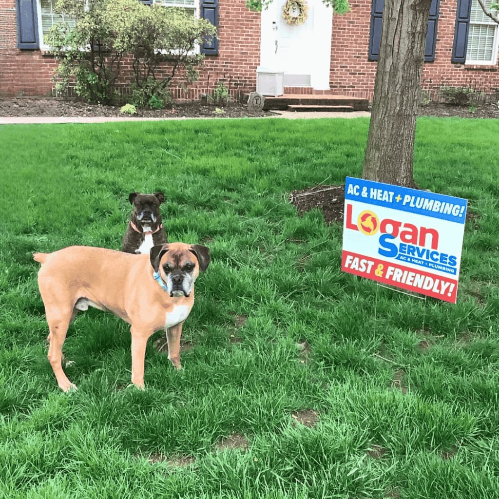 Customer's dogs with a Logan Services yard sign