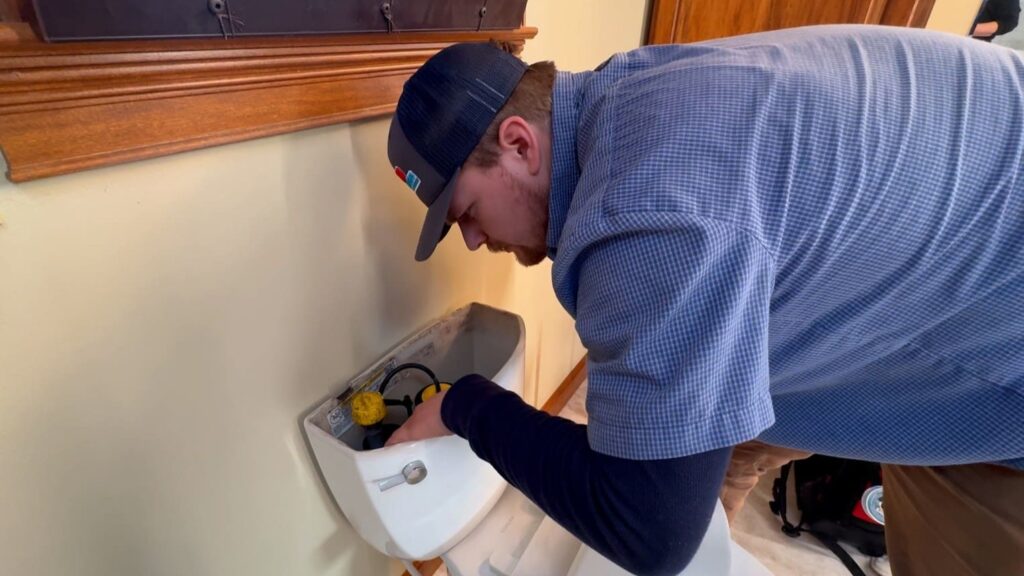 Logan Services plumber inspecting toilet for leaks.