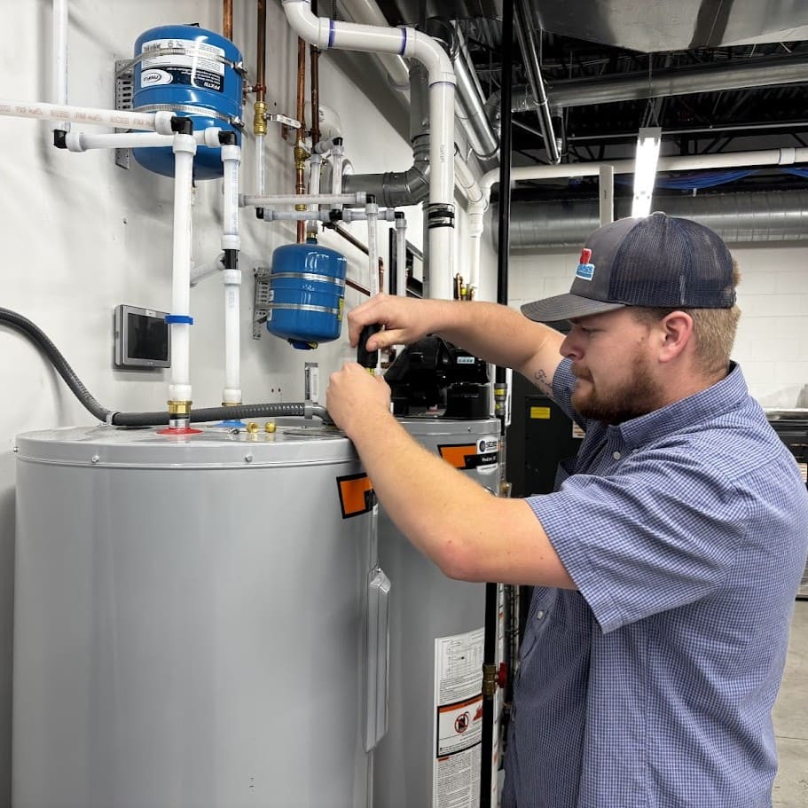 Logan Services plumber performing maintenance on a State tank water heater.