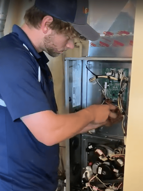 LSI HVAC technician repairing control board on furnace.