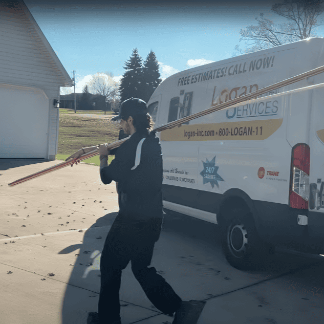 Logan Services plumber carrying pipe to install.
