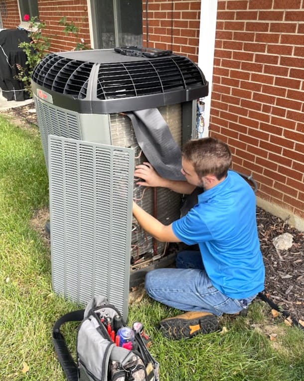 Logan Services HVAC technician performing heat pump maintenance.