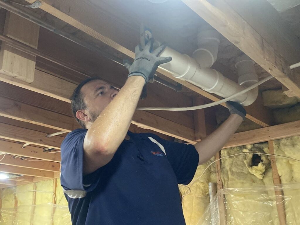 Logan Services plumber replacing pipes in local customer's home.