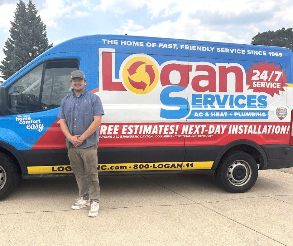 Logan Services plumber posing with branded van
