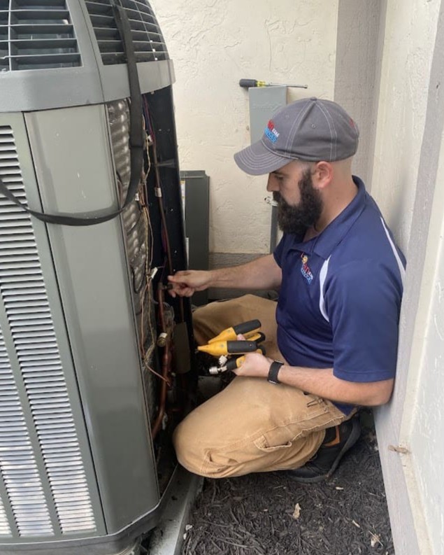 Logan Services HVAC technician tuning up heat pump.