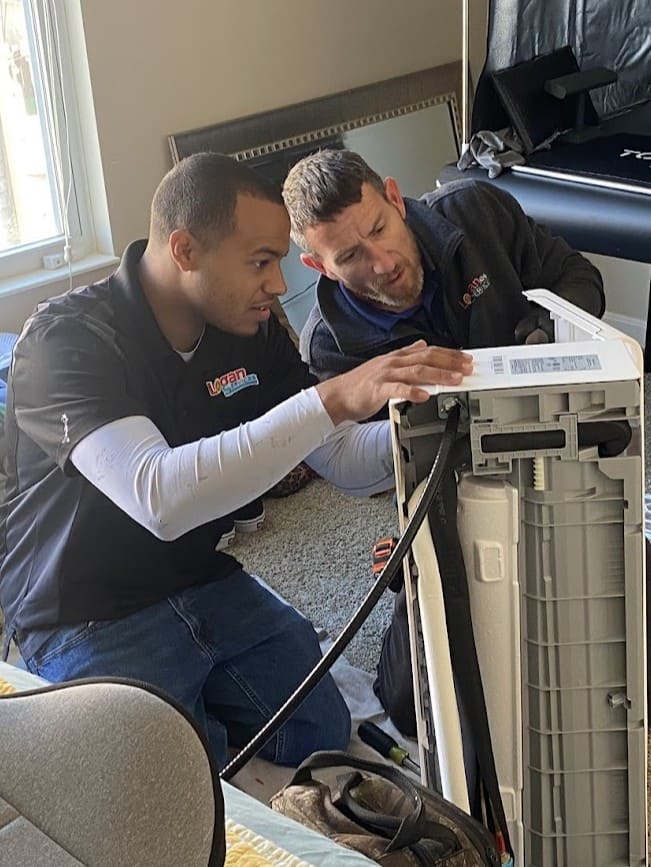 Logan Services HVAC installers inspecting a new mini-split head