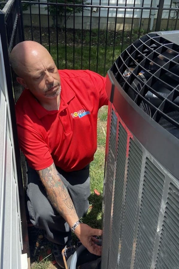 Logan Services HVAC technician servicing heat pump in Columbus, OH.