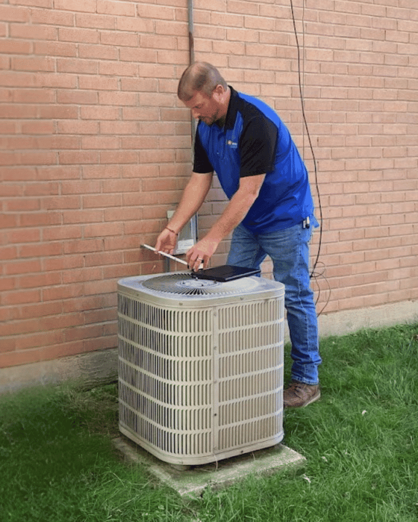 Logan Services salesman measuring old AC unit