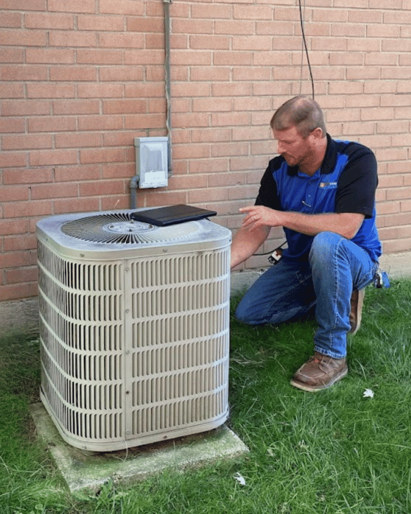 Logan Services salesman inspecting AC unit