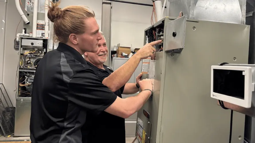 Logan Services HVAC technician working on Trane furnace