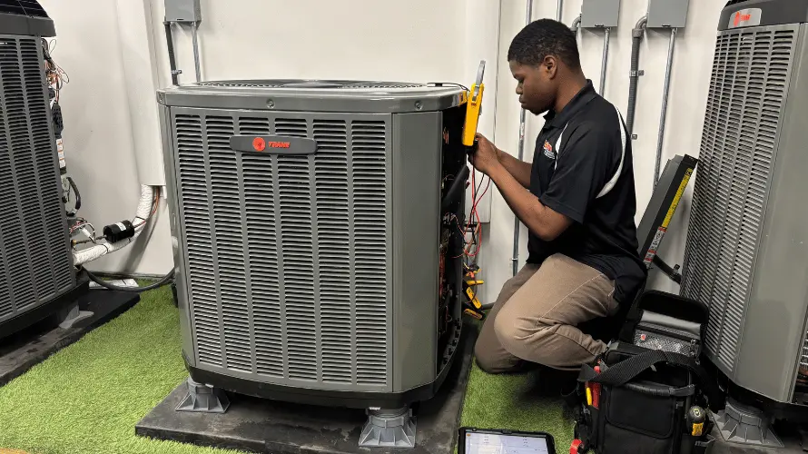 Logan Services HVAC apprentice working on Trane AC