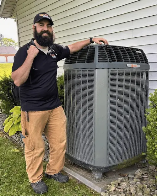 Logan Services HVAC technician posing with Trane AC