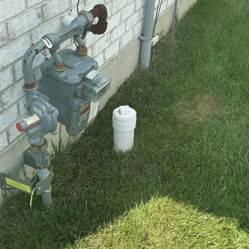 White sewer cleanout next to house